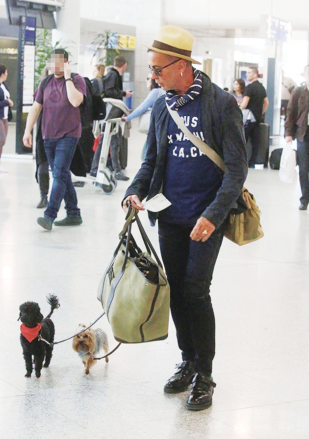 Φορτωμένος μπαγκάζια και κρατώντας τα σκυλάκια του ο Λάκης Γαβαλάς