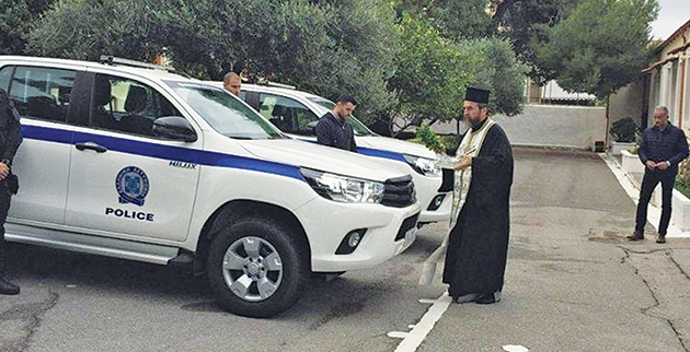 Ιερέας αγιάζει τα νέα αυτοκίνητα της ΕΛ.ΑΣ. • Φωτό: zarpanews.gr
