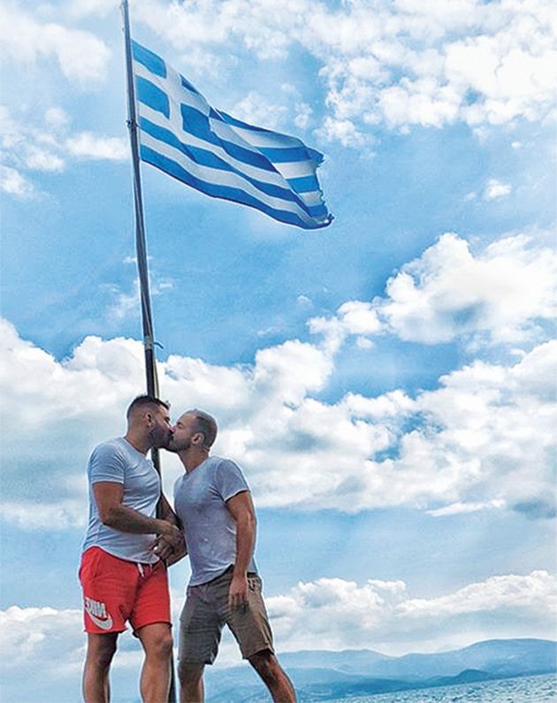 Ο ΥΠΑΣΤΥΝΟΜΟΣ Μιχάλης Λώλης δίνει παθιασμένο φιλί σε μελαψό άνδρα κάτω από την ελληνική σημαία