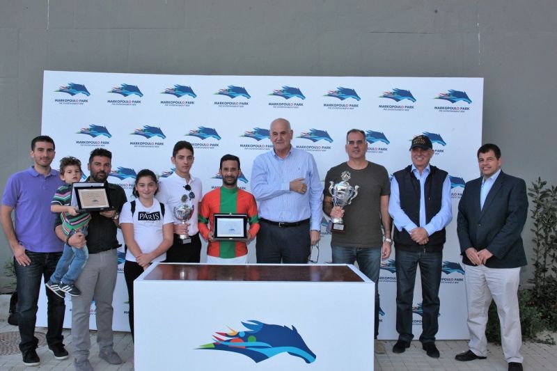 Από αριστερά ο Project Manager της ΙΠΠΟΔΡΟΜΙΕΣ Α.Ε. Βύρωνας Κακλόπουλος, ο προπονητής Χρήστος Σταύρου με τα παιδιά του Φίλιππο, Χριστιάννα και Άγγελο, ο αναβάτης Μιχάλης Ξυνός, ο Διευθυντής Τεχνικών Υπηρεσιών της ΙΠΠΟΔΡΟΜΙΕΣ Α.Ε. Γιώργος Αγγελόπουλος, ο συνιδιοκτήτης του ΡΑΝ ΤΟΥ ΔΕ ΧΙΛΣ Μάριος Κουτσομύτης, ο Α’ Αντιπρόεδρος της ΙΠΠΟΔΡΟΜΙΕΣ Α.Ε. Σπύρος Φωκάς και το μέλος της Επιτροπής Ιπποδρομιών Σέργιος Σπασσώφ.