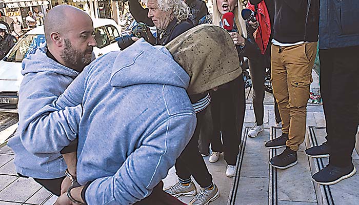 Ο νεαρός Ρομά ενώ οδηγείται στον ανακριτή