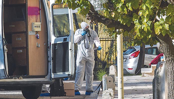 Ανδρας του ΤΕΕΜ ψάχνει στον χώρο για στοιχεία