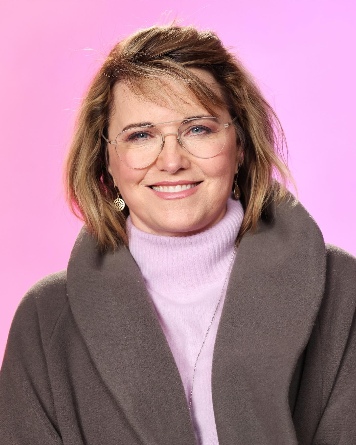 Photo shared by Lucy Lawless on January 20 2024 tagging @reallucylawless. May be an image of 1 person makeup eyeglasses fleece and turtleneck